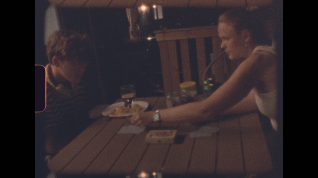 People at a table eating and playing cards