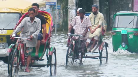 bangladesh cycling taxi bikes transporting people through flooded downtown sylhet city street