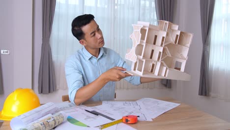 young architect hold house model and looking