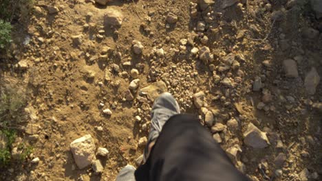 Video-En-Cámara-Lenta-De-Un-Hombre-Caminando-En-Entrenadores-Grises-En-Las-Montañas