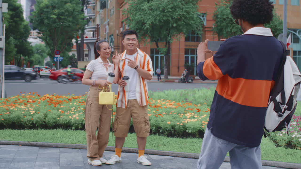 Man Taking Photo of His Friends during City Walk