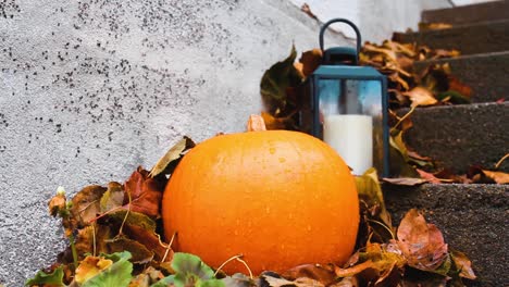 halloween pumpkin and small lantern outside porch