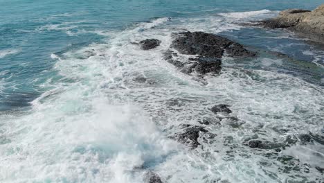 Olas-Turquesas-Rodando-Sobre-Roca-Negra--antena