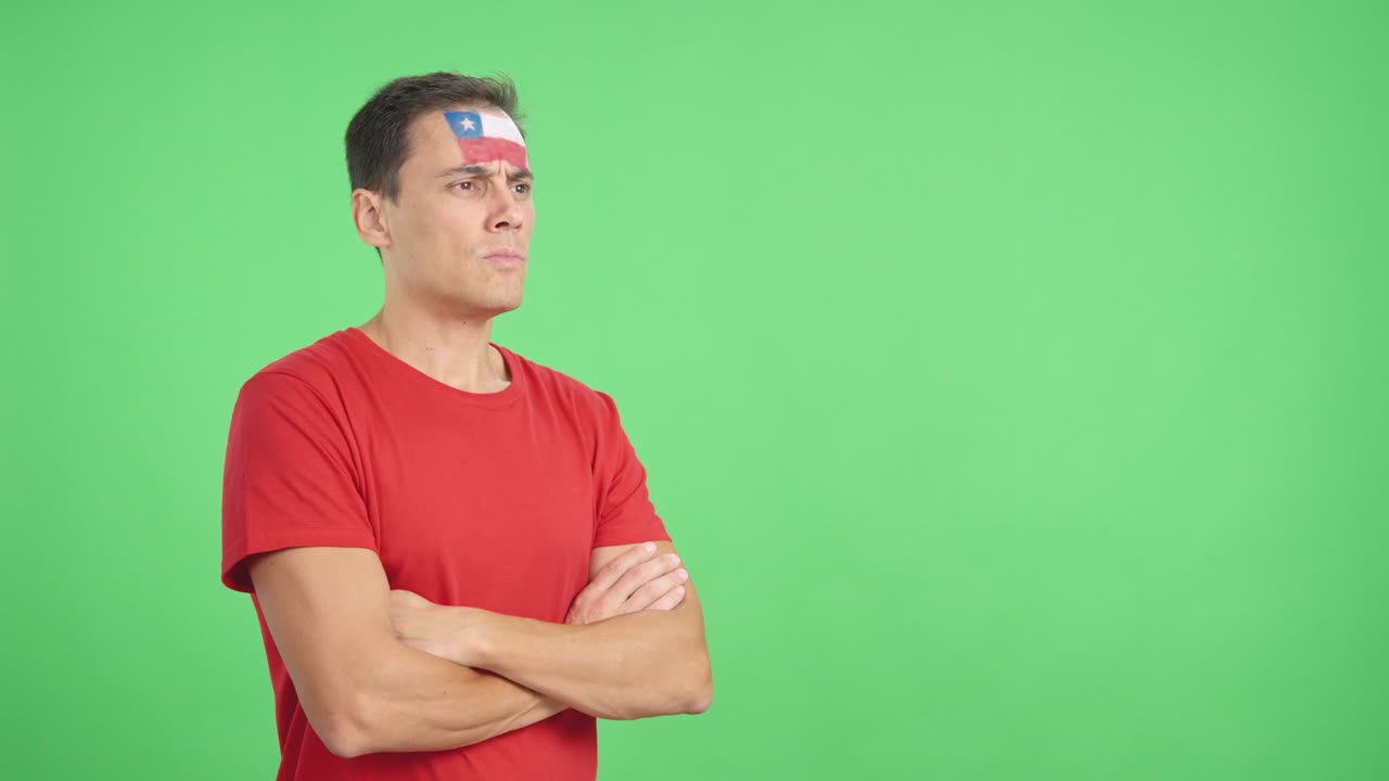 Man with chilean flag painted looking away with serious expression