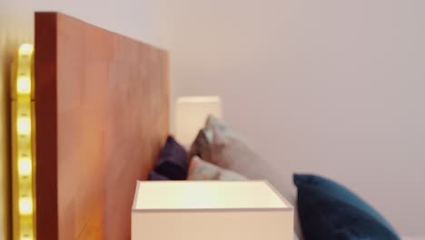 slow-descending-shot-of-a-bed-with-built-in-LED-headboard-with-lamp