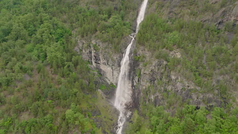 reverse reveal cataract waterfall plunging from high rocky clifftop into ravine