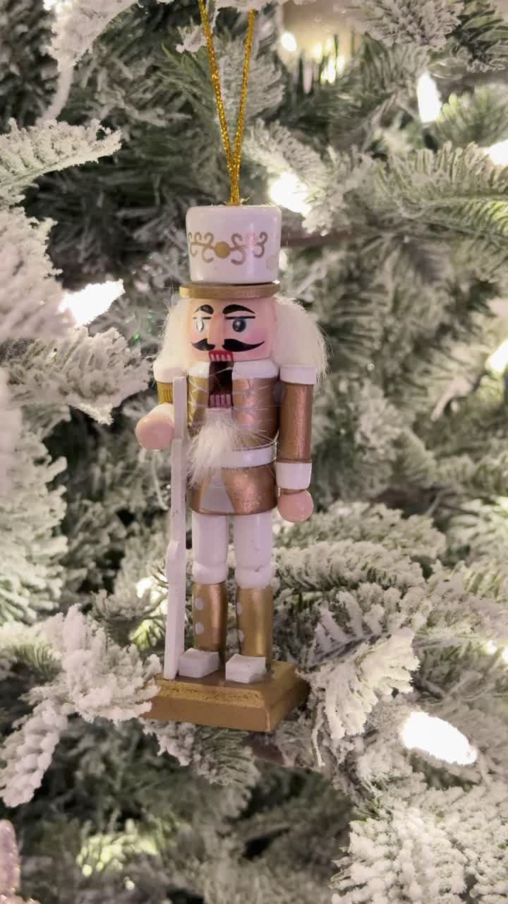 Nutcracker on snowy Christmas tree, festive mood, vertical shot