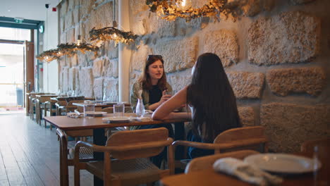 two women having a conversation at a restaurant