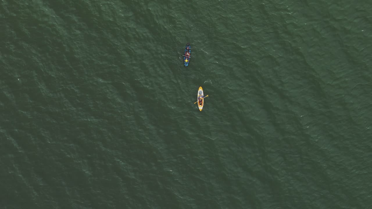 dos kayaks se deslizan pacíficamente a través de las aguas tranquilas del mar