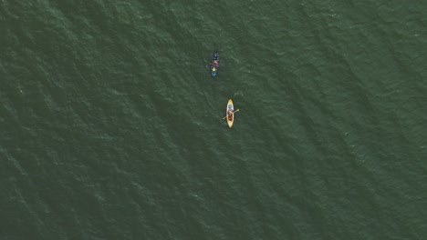 two kayaks glide peacefully through the calm waters of the sea