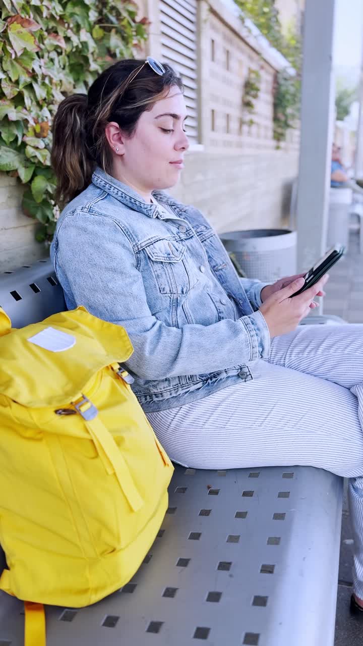 Smiling Woman Using Her Phone at a Train Station Platform