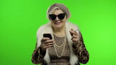 elderly stylish trendy caucasian grandmother woman using smartphone. chroma key