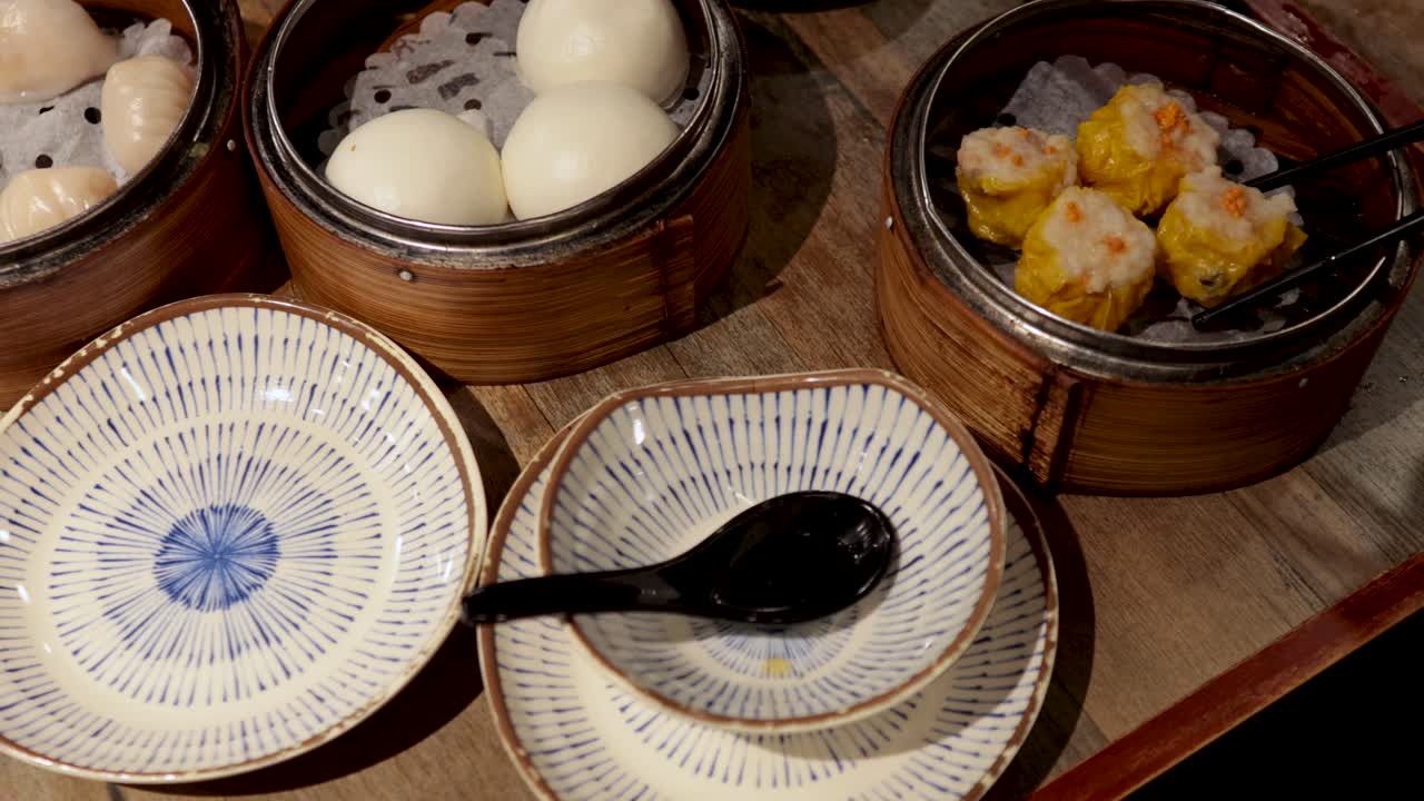 Chopsticks picking dumplings from bamboo steamer
