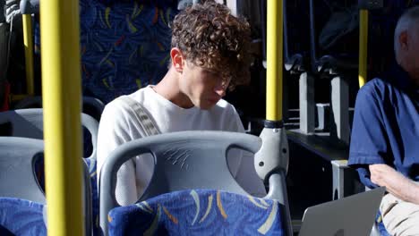 pasajero masculino que usa una computadora portátil mientras viaja en el autobús 4k