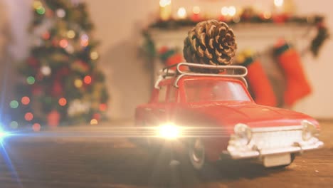 Composition-of-light-over-christmas-decorations-with-car-and-pine-cone