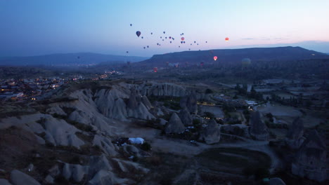 Morgendämmerung-In-Kappadokien-Mit-Ballons,-Die-über-Markanten-Felsformationen-Schweben