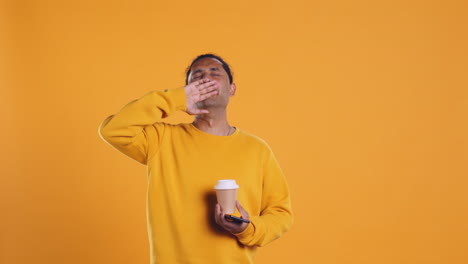 man drinking coffee and chatting with friends on mobile phone, studio background