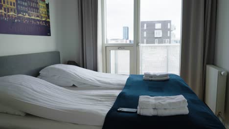 beautifully made bed at hotel bedroom with large window, copenhagen