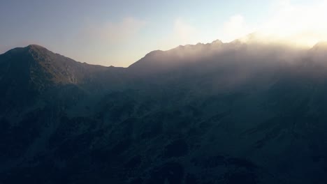 clouds rolling over the peaks of mountain peaks