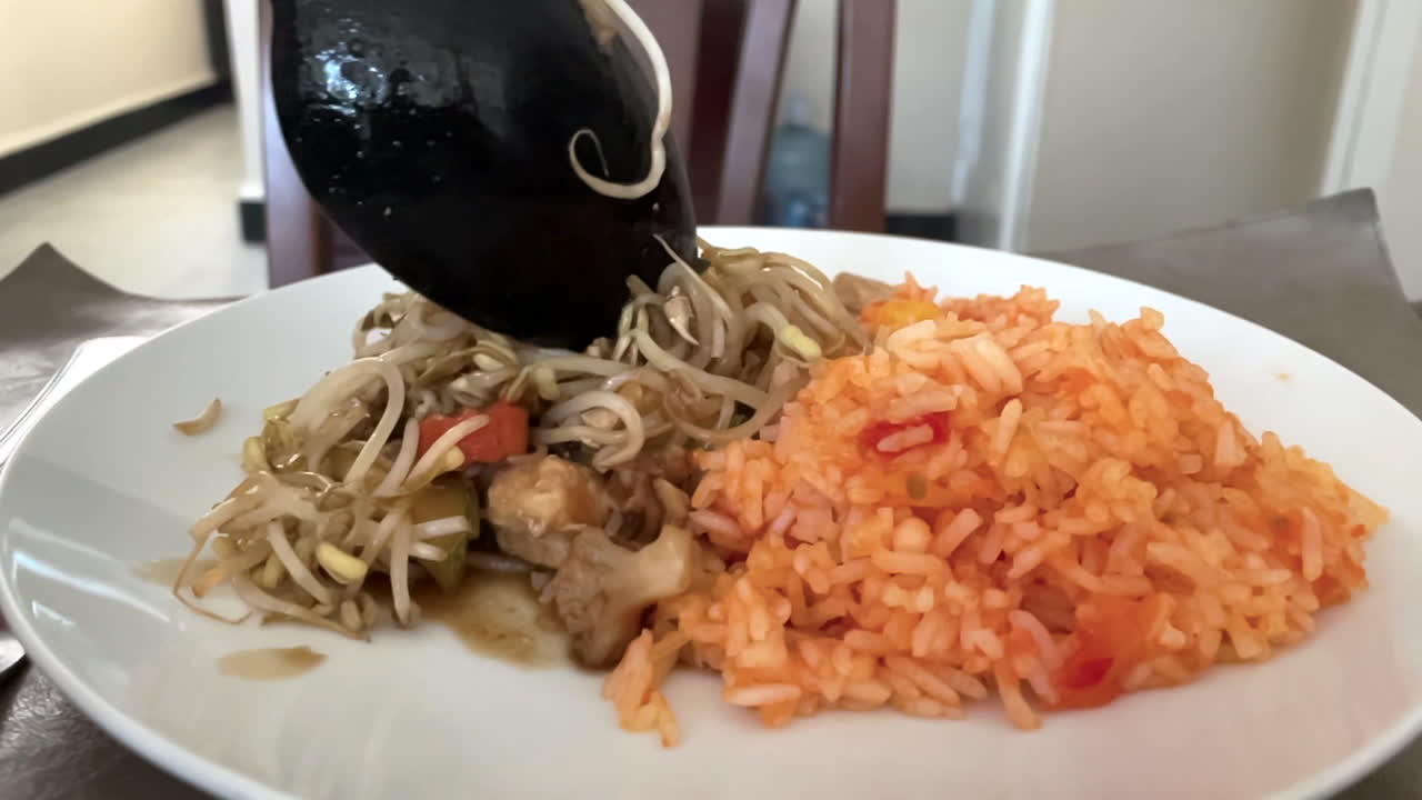 toma en cámara lenta de chop suey y arroz rojo mezclados en abundancia
