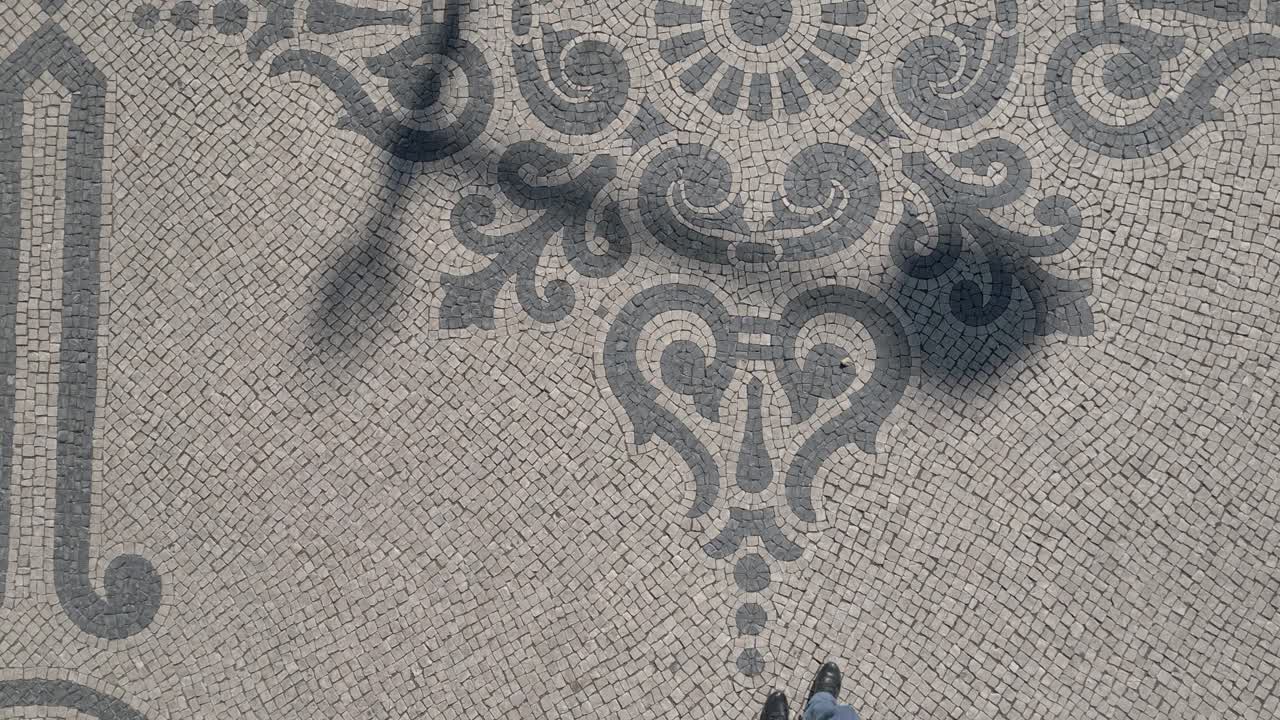 vista superior de los mosaicos en la calle visibles mientras se camina
