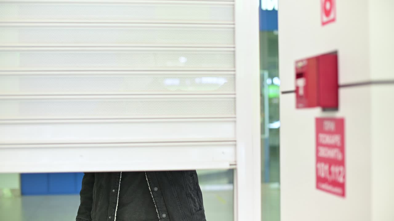 un tendero y un empleado con una máscara médica cierran su tienda