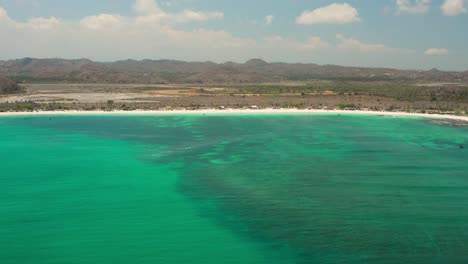the white sand beach of tanjung aan in lombok, indonesia during a sunny day