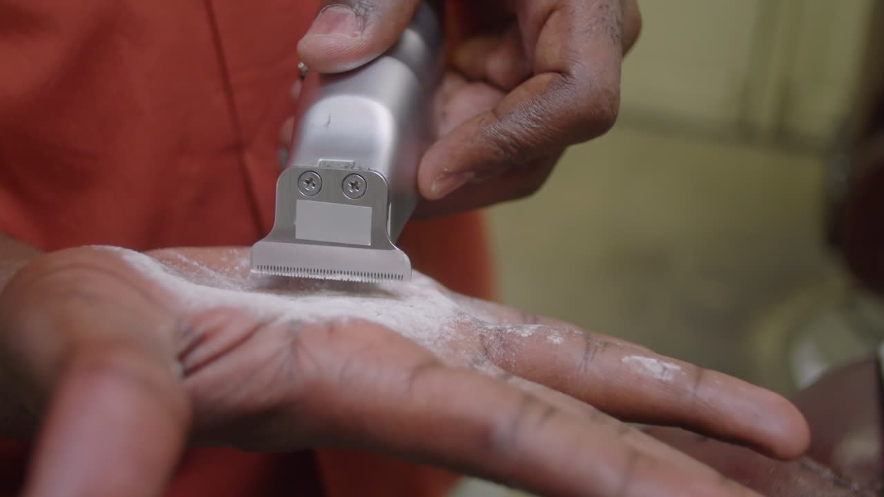 Barber Applying Powder to Razor while Doing Haircut