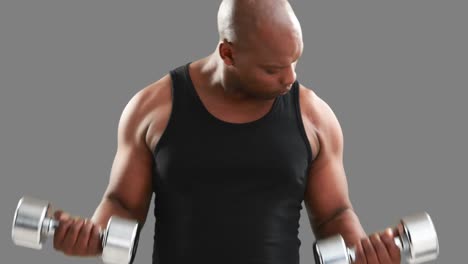 serious muscular man lifting dumbbells