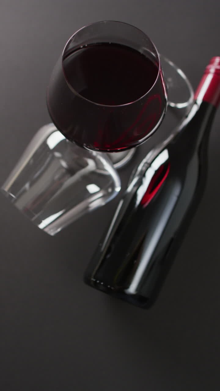 Vertical video of red wine glasses on wooden surface