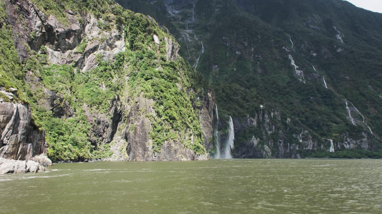 밀포드 사운드 (milford sound) 에서 멀리 떨어진 폭포를 바라보는 배에서 숨을 는 관점