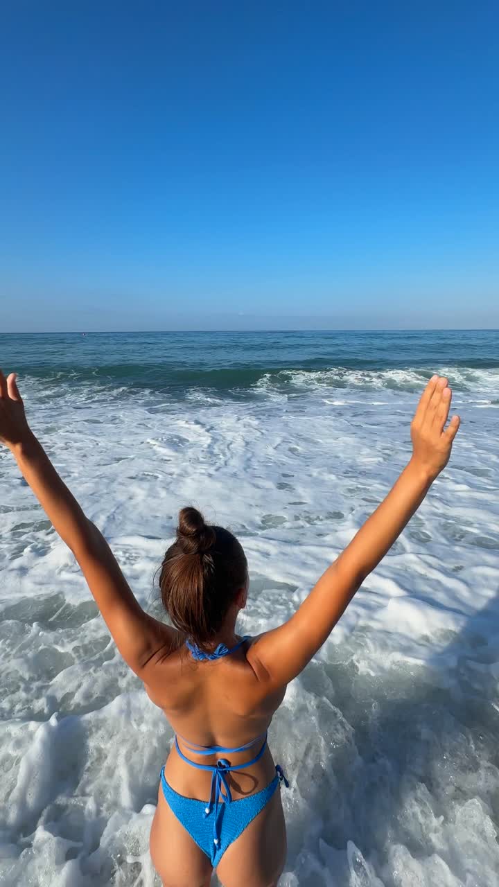 파도가 있는 해변에서 파란 비키니를 입은 여자