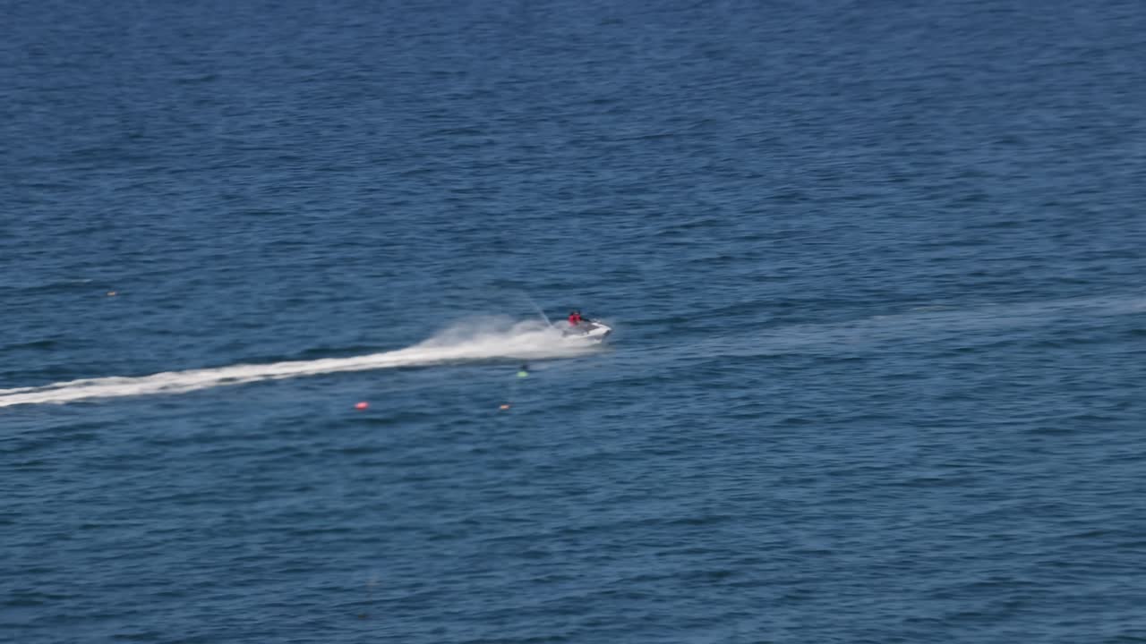 Ripresa a mano in movimento di un moto d'acqua che sfreccia sull'oceano a Newquay, Cornovaglia