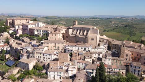 wide angle drone shot flying upwards towards a church and a very old village revealing the vista behind it