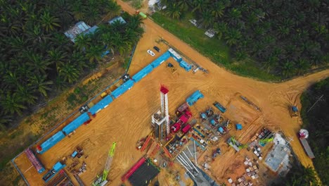 Cinematic-Onshore-Drilling-and-Workover-Rig-structure-and-Rig-equipment-for-oil-exploration-and-exploitation-in-the-middle-of-jungle-surrounded-by-palm-oil-trees-during-sunset-time