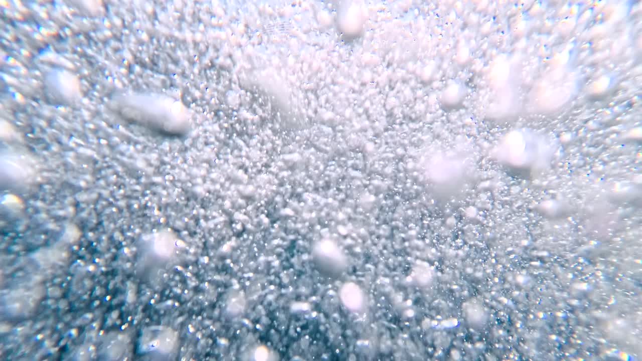POV di un pedalò giallo sull'acqua di mare blu con una boa rossa. Si vedono i piedi, suggerendo