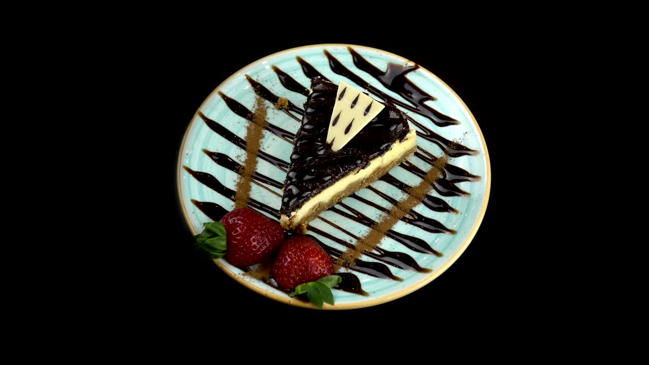 초콜릿 치즈케이크 접시가 검은색 배경으로 회전