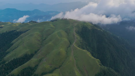 drone shot of clouds floating over lush green hills in dolakha sailung, nepal, with majestic mountain ranges serene and prosperous landscape exemplifies the beauty of nepal’s tourism potential