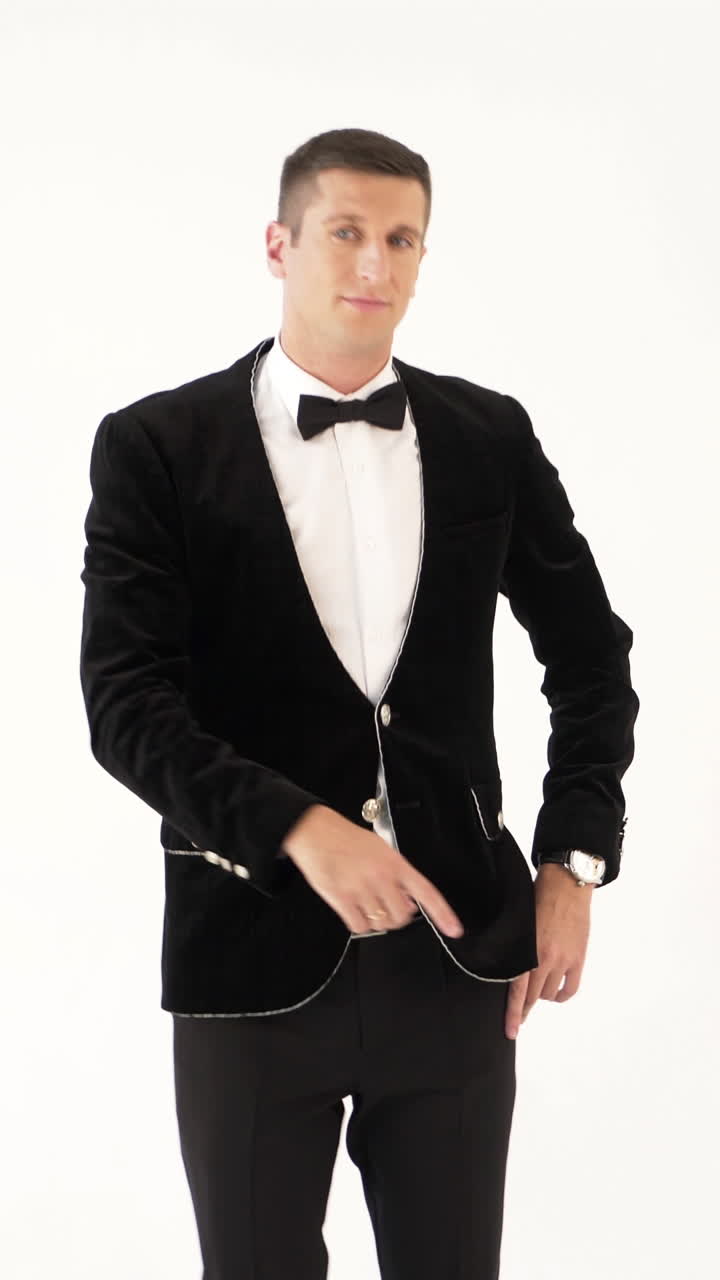 humorist in trendy costume is parodying a man who dancing in a club on a white background in the studio Vertical video