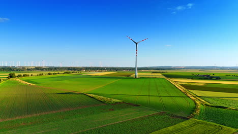 approaching a wind turbine rotating in the field. flight over the green plantation in the countryside. clean energy concept.