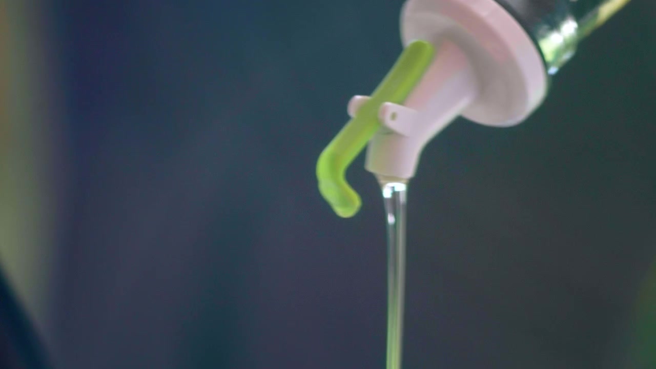 Detail shot, olive oil jet in salad bowl.