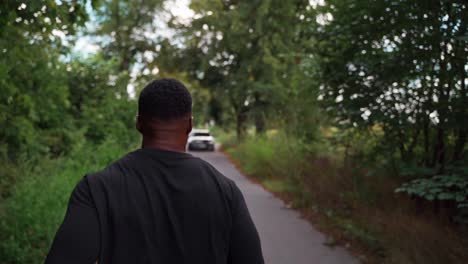 back view of african man jogging in a park in slow motion