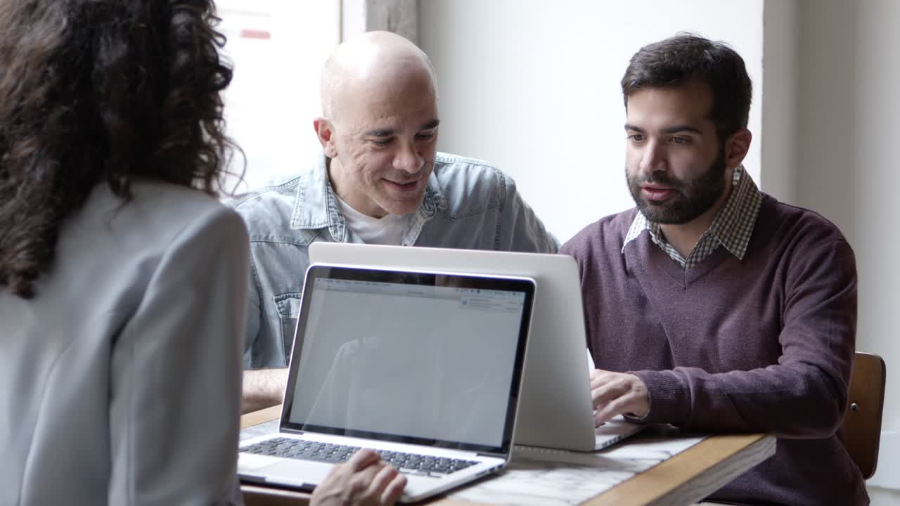 gerentes confiados discutiendo un nuevo proyecto con computadoras portátiles