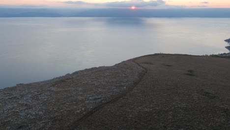 High-aerial-of-inland-sea-of-galilee-in-Israel-as-sunsets-on-cloudy-horizon