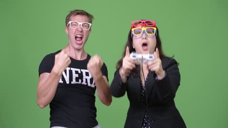 una mujer de negocios asiática madura y un joven nerd escandinavo jugando juntos.