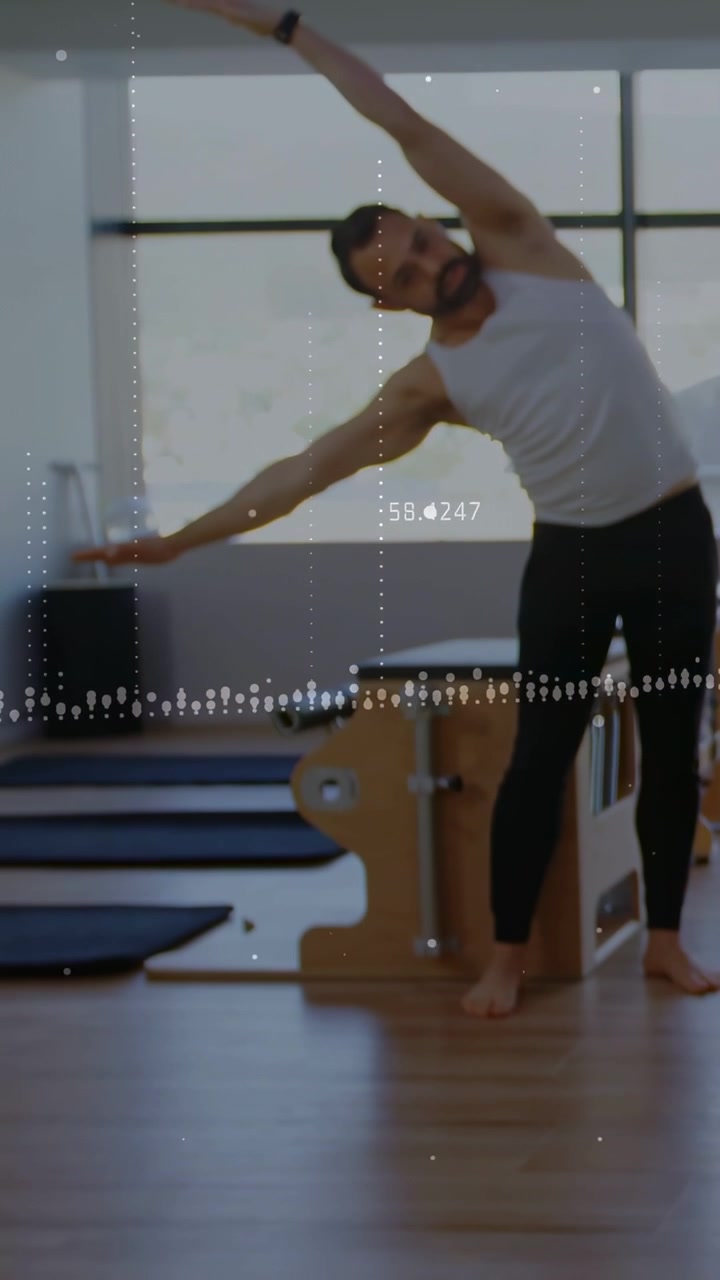 Vídeo vertical: homem começando na cadeira de Pilates, fazendo inclinações laterais com sobreposição de gráfico auxiliando o equilíbrio