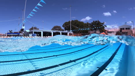 Split-View-Underwater-Of-Athlete-Swimming-Freestyle-In-Blue-Olympic-Pool,-4K-Slow-Motion