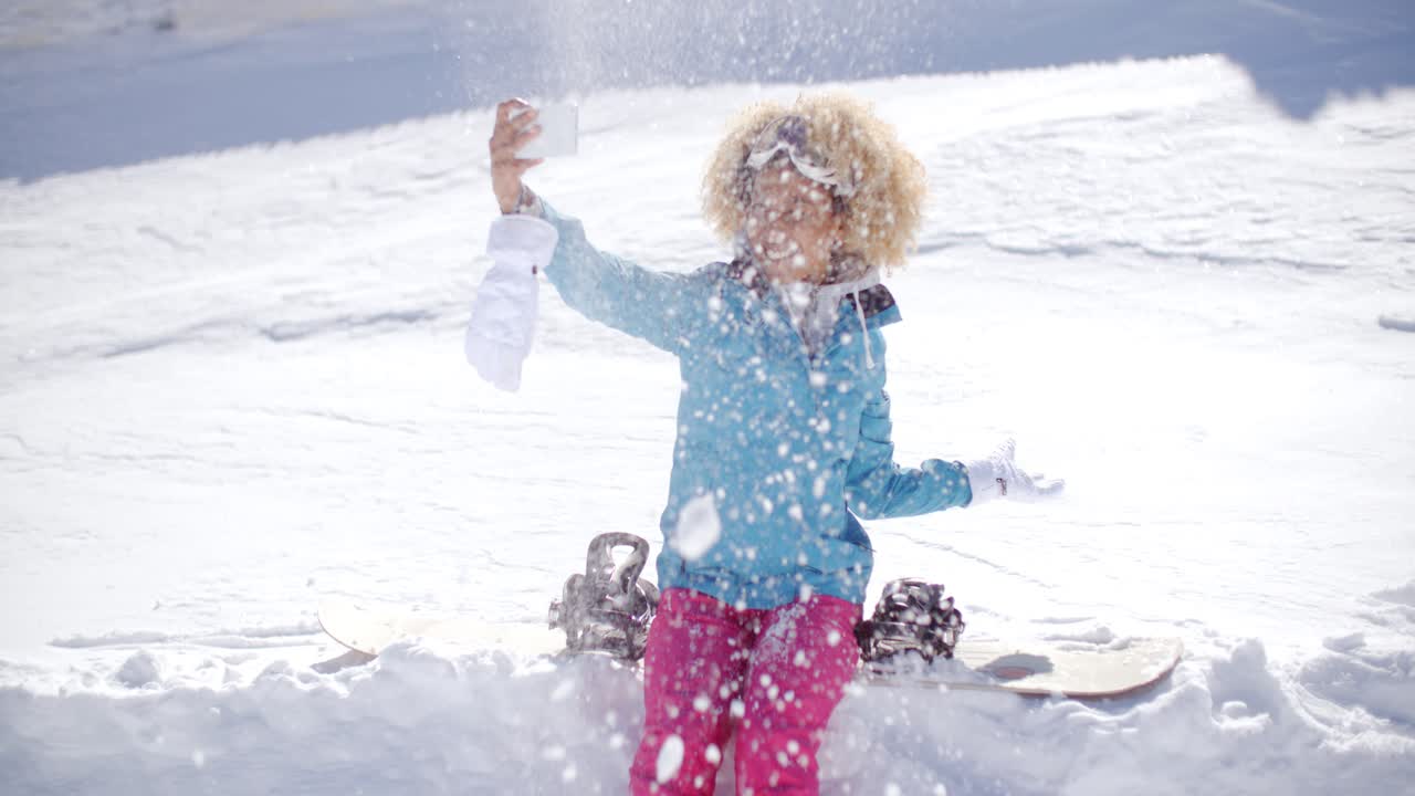mujer lúdica posando para una selfie en la nieve