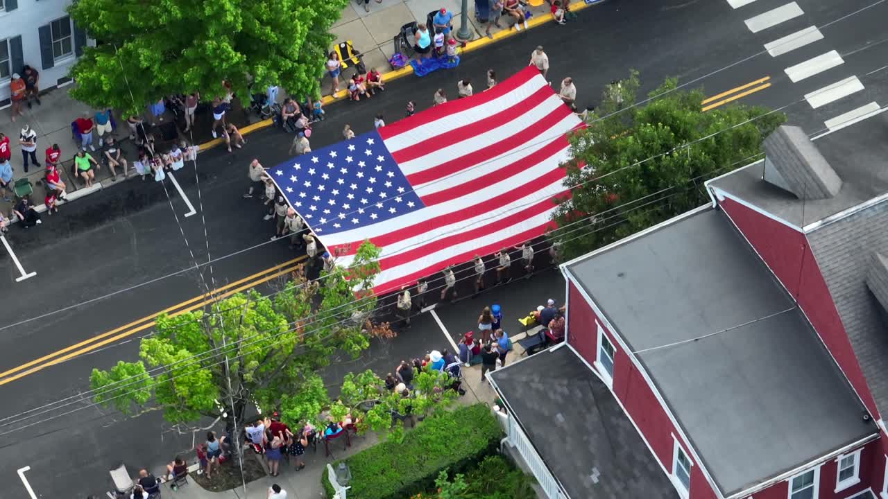거대한 미국  ⁇ 발이 독립기념일에 마을의 주요 거리를 따라 옮겨졌습니다.