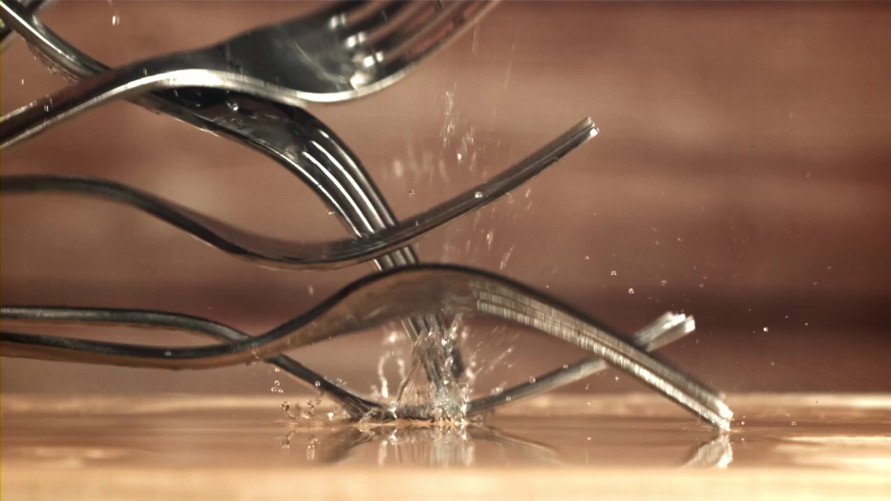 Metal Forks Falling and Splashing Water in Slow Motion